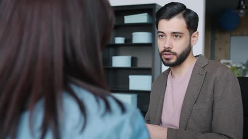 Middle Eastern Man Talking To Female Colleague Discussing Business in Office