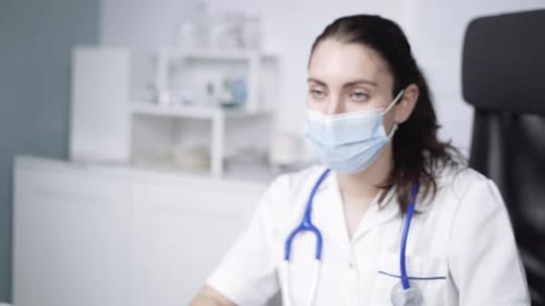 Physician sharing document and speaking with unrecognizable patient in clinic