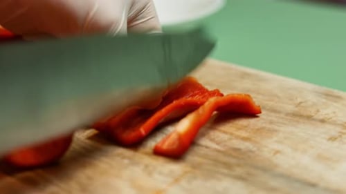 Slicing a Red Pepper on Wooden Cutting Board