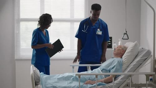 Senior Patient on Bed Talking to 2 African American Doctor in Hospital Room Health Care and
