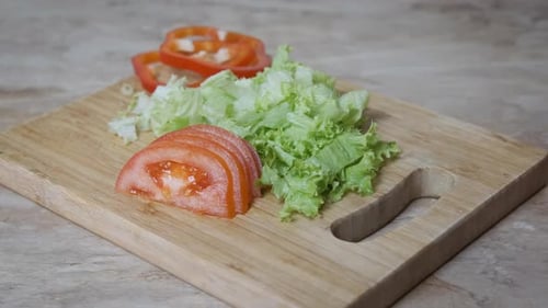 Fresh Lettuce, Tomatoes, and Peppers on Cutting Board