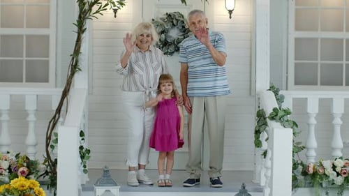 Grandparents and Child Waving on Decorated Porch