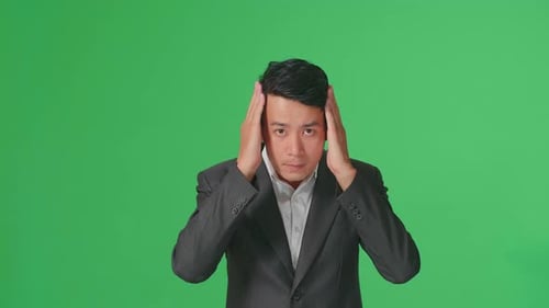 Asian Business Man Touching His Hair While Looking At Camera Like A Mirror On Green Screen In Studio