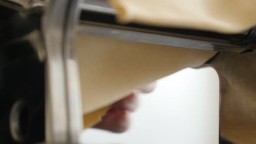 Fresh Pasta Dough Being Rolled by Machine