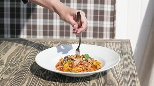 Italian Cuisine in Restaurant Eating Spaghetti Pasta with Vegetables with a Fork Closeup