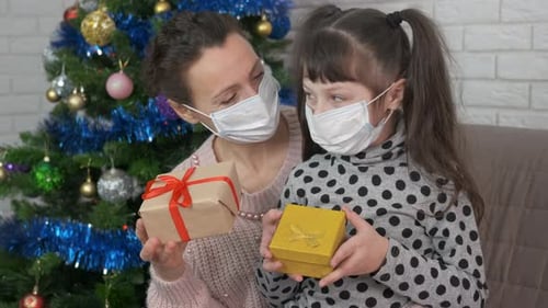 Mother and Child with Christmas Presents Wearing Masks