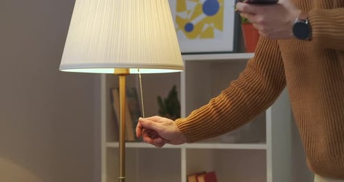 Man Is Turning Off Floor Lamp in Living Room or Bedroom at Evening Interior of Modern Apartment