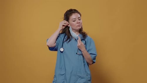 Woman in Scrubs Puts On Face Mask