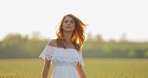 Beautiful Girl in a White Dress Walks on a Sunny Summer Day. Young Woman Is Happy. Portrait View