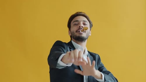 Man Dances with Party Hat and Horn, Yellow Background