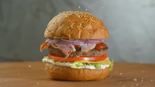 Close Up of Burger Being Sprinkled with Sesame Seeds