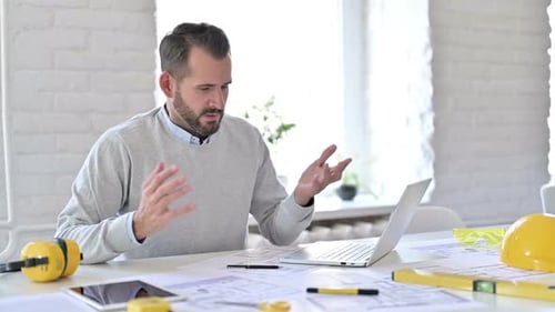 Frustrated Architect Gesturing at Laptop in Bright Office