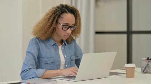 African Woman Working on Laptop in Office