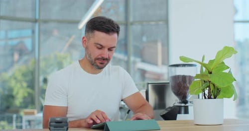 Handsome Man Barista Standing at Counter in Bar Looking at Camera