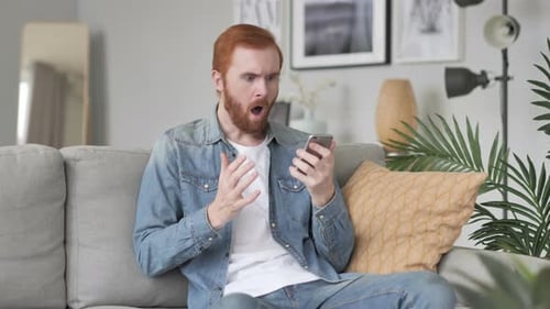 Man Reacts to Something on His Phone