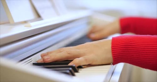 Close Up of Hands Playing White Piano