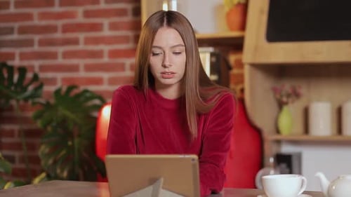 Woman Uses Tablet Device Indoors At Table