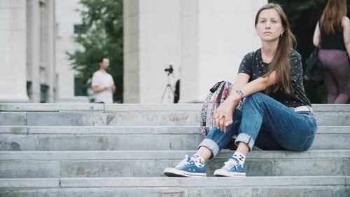 Woman Sitting on Steps in an Urban Environment
