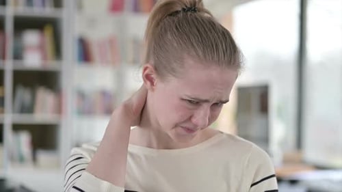 Young Adult Woman Rubbing Her Neck in Discomfort