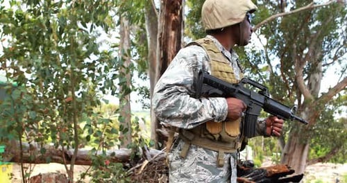 Adult Soldier Holding Rifle in Forest Clearing