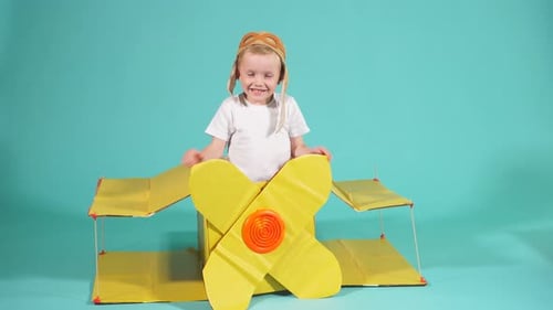 Pilot Boy mit Pappflugzeug isoliert über blauem Hintergrund.