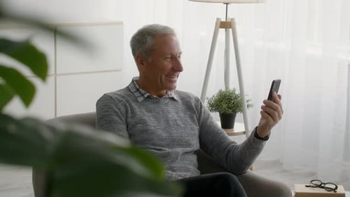 Senior Man Video Calling from Home on Smartphone