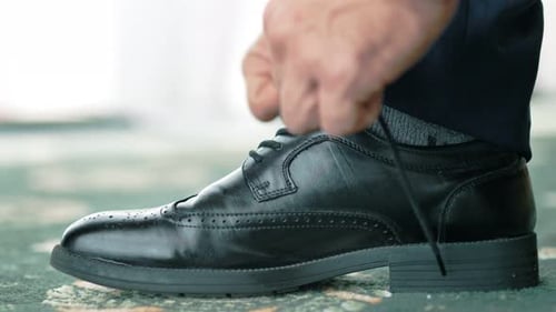Man Tying Black Leather Dress Shoe