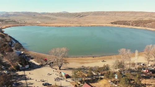 Menschen, die am runden blauen See spazieren