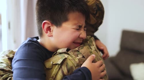 Emotional Reunion: Child Embraces Military Personnel