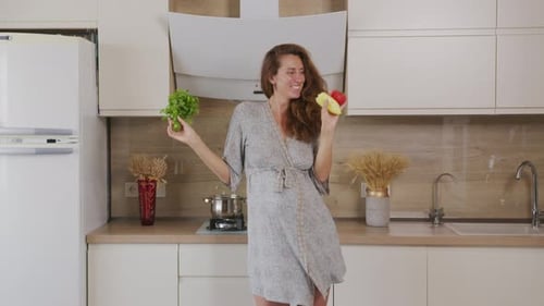 Happy Woman Dancing with Produce in Bright Kitchen