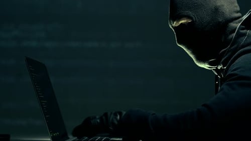 Hacker mascarado na frente de seu laptop