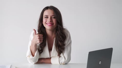 Smiling Woman Gives Thumbs Up in Office Setting