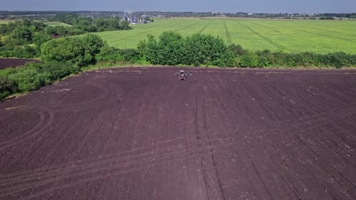 Tractor Tilling Center of Farm Field in the Fall