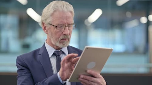 Senior Man Using Tablet in Office