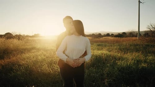 Romantic Couple Embracing in a Golden Field at Sunset