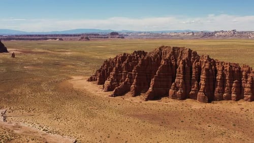 Eine wunderschöne Drohnenaufnahme einer atemberaubenden Wüstenszene mit orangefarbenem Sand und großen roten Felsformaten