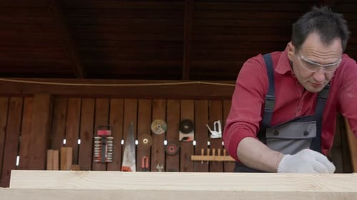 Carpenter marking wood plank in his workshop