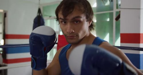 Caucasian man boxing in boxing gym