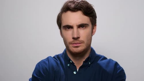 Serious Man on White Background. Thoughtful Guy Looking at Camera in Studio