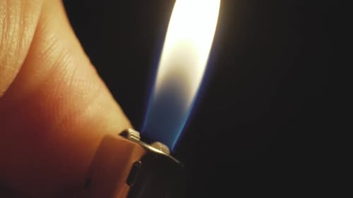 Plan rapproché au ralenti d'un briquet sur la main de l'homme