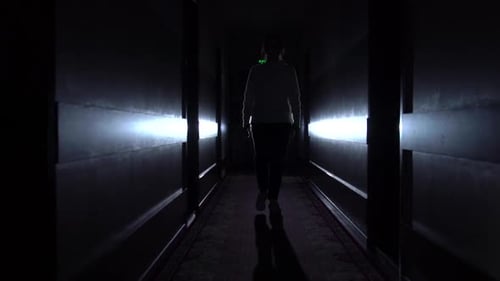 Person Walking Down Dark Hallway