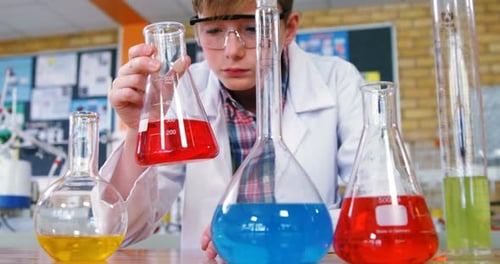 Young Scientist Examining Colorful Liquids in Lab
