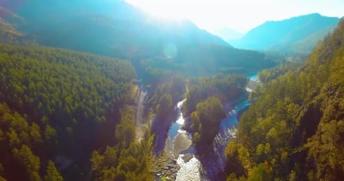 Mid Air Flight Over Fresh Mountain River and Meadow at Sunny Summer Morning. Rural Dirt Road Below