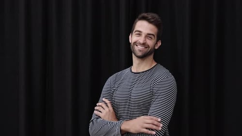 Smiling Young Man Poses in Studio with Black Backdrop