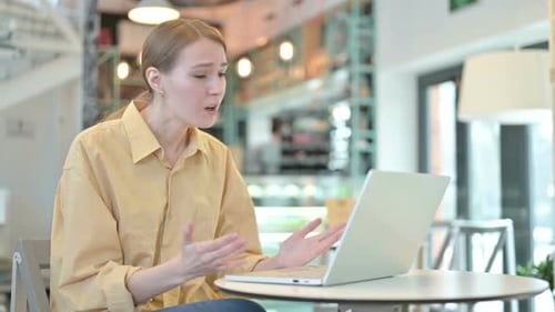 Young Woman Upset By Loss on Laptop in Cafe