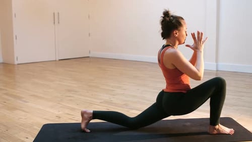 Woman Doing Yoga on Mat in Studio