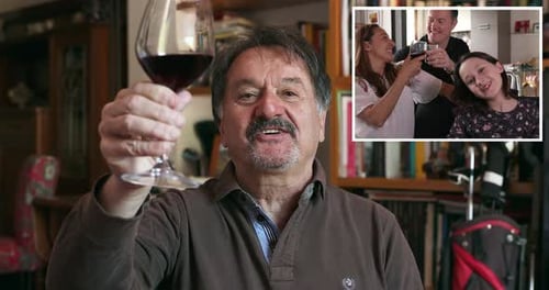 Man Toasts with Family Over Video Call