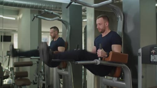 Hombre en forma realizando ejercicios de levantamiento de piernas colgantes