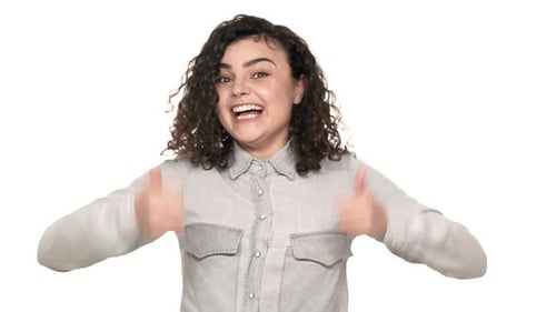 Porträt einer attraktiven jungen Frau im Freizeithemd, die lächelnd und gestikulierend vor der Kamera erscheint