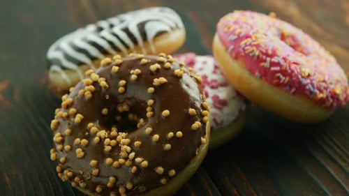 Delicious Donuts with Colorful Frosting on Wood Surface